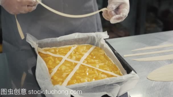 人準(zhǔn)備水果橙色檸檬餡餅在廚房桌上, 最后的裝飾在手套, 餐廳廚房烘焙產(chǎn)品工廠